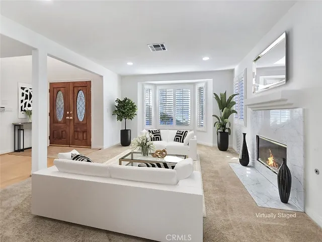 a living room with furniture fireplace and potted plants