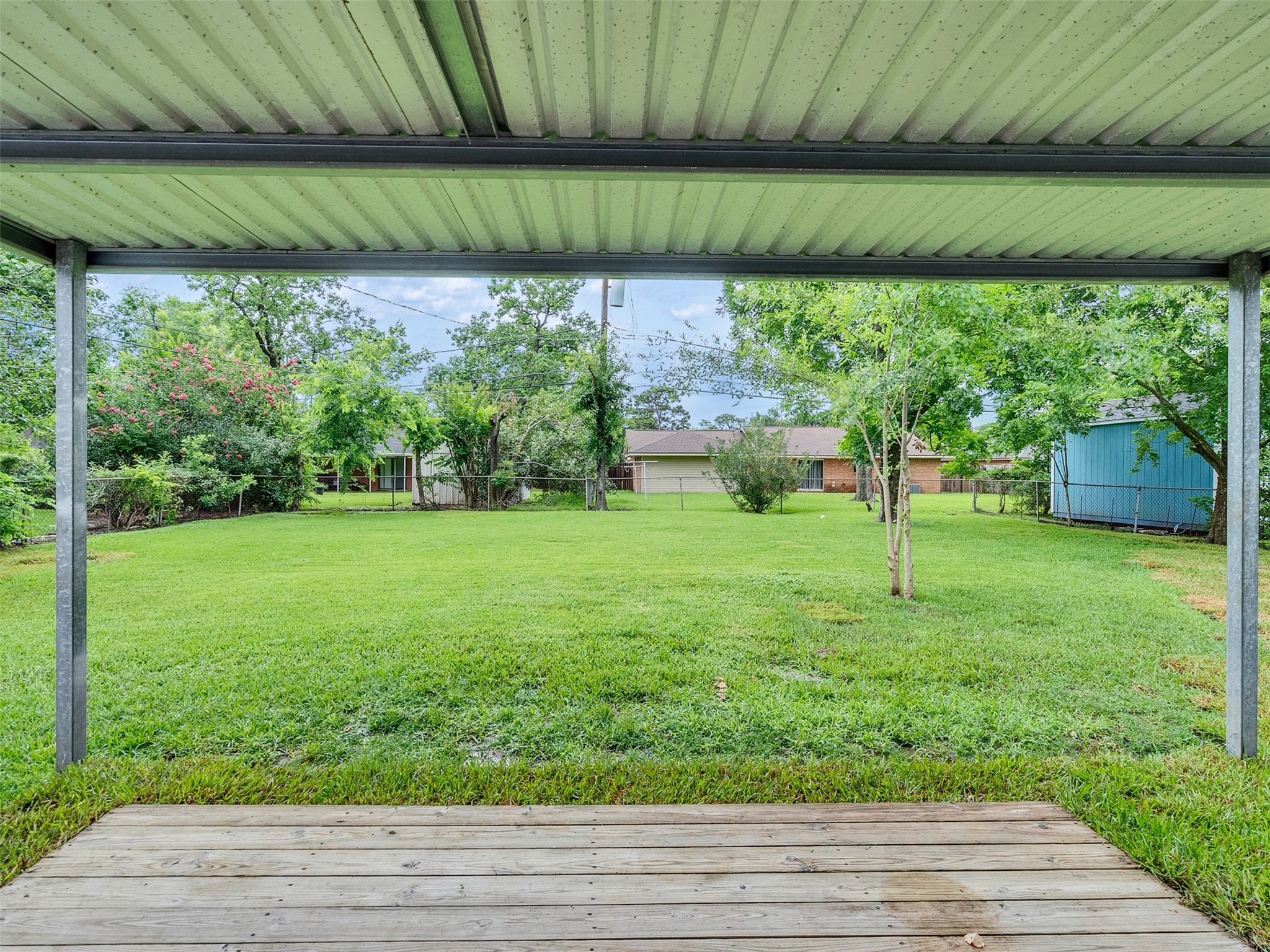 10315 Winding Trail Road La Porte, TX 77571 - Photo 20 of 24 Enjoy serene outdoor living with this inviting covered patio overlooking a spacious, lush backyard—perfect for relaxing or entertaining.