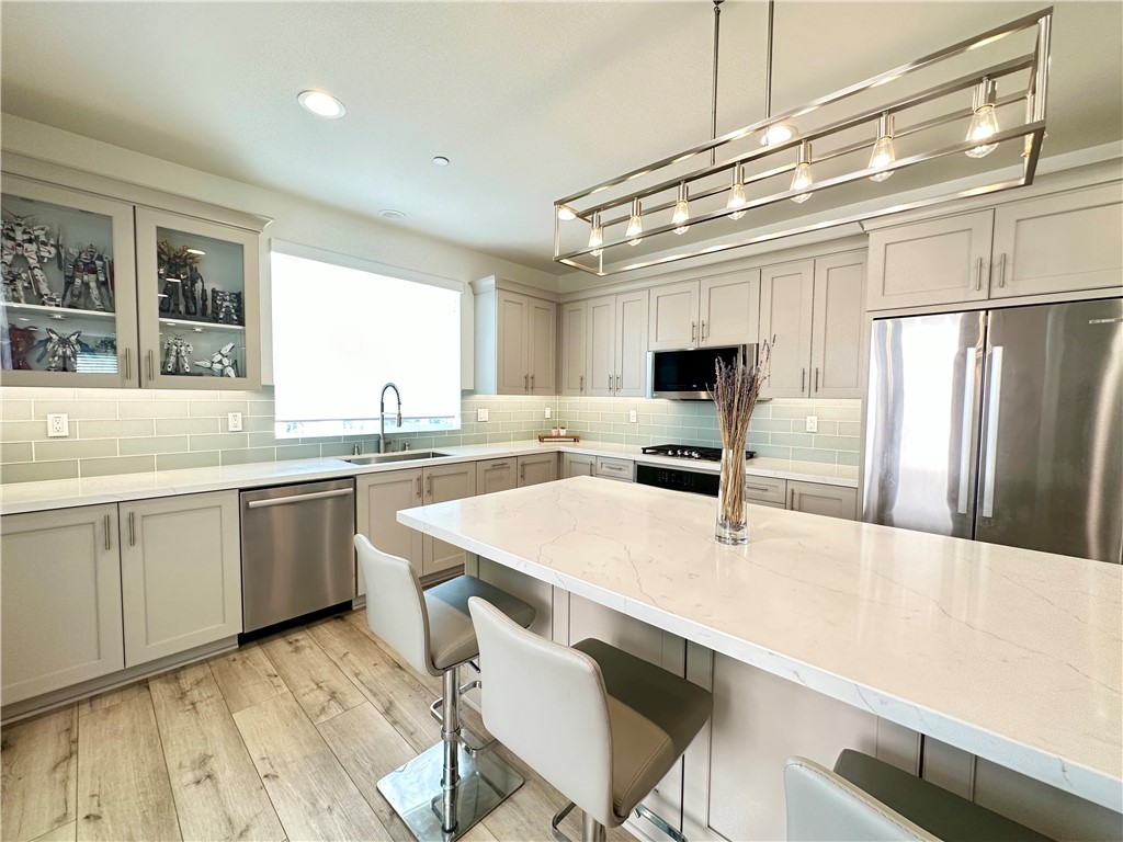 35 Hideaway Loop Mission Viejo, CA 92692 - Photo 4 of 24 a kitchen with kitchen island a sink table and chairs