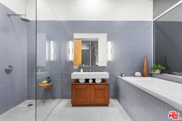 a bathroom with a tub sink and mirror