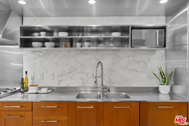 a kitchen with granite countertop a sink a stove and cabinets