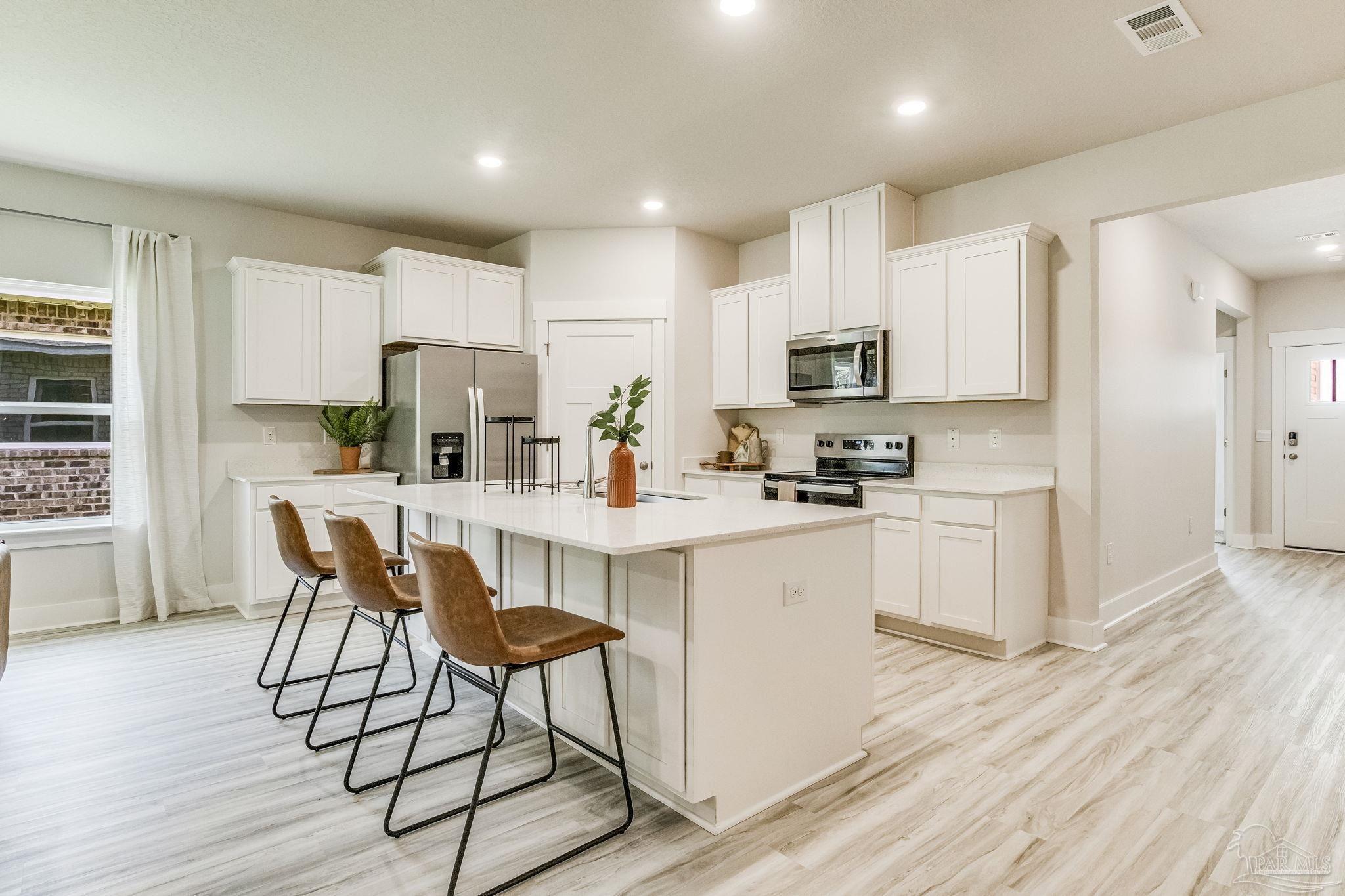 3861 Eagle Tail Drive Jay, FL 32565 - Photo 3 of 20 a kitchen with stainless steel appliances a stove a sink a refrigerator and a microwave