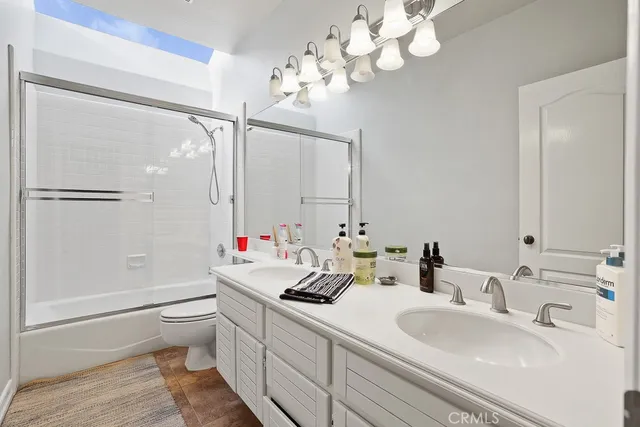 a bathroom with a sink a toilet and a mirror