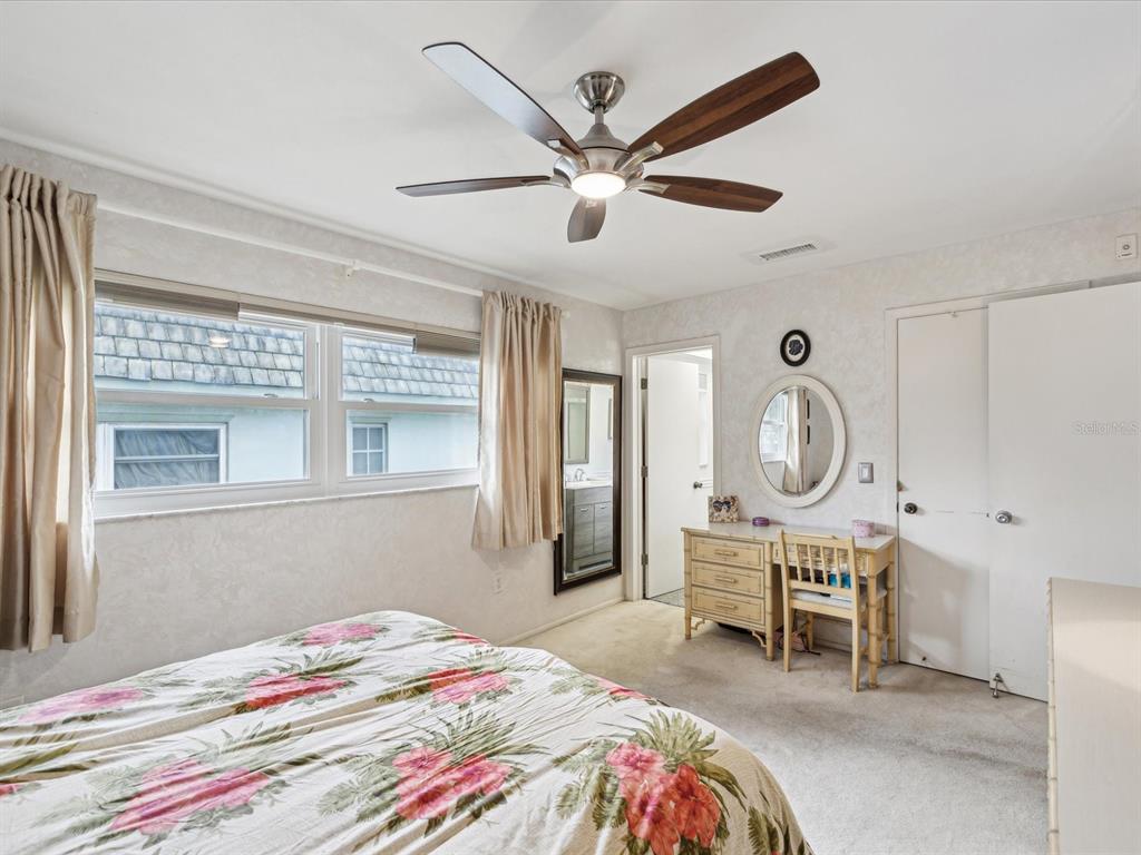 1433 South Belcher Road, Unit F20 Clearwater, FL 33764 - Photo 15 of 57 a bedroom with a bed a chandelier and chair