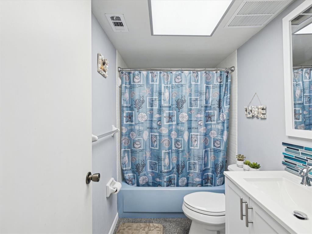 1433 South Belcher Road, Unit F20 Clearwater, FL 33764 - Photo 24 of 57 a bathroom with a sink a toilet and shower curtain