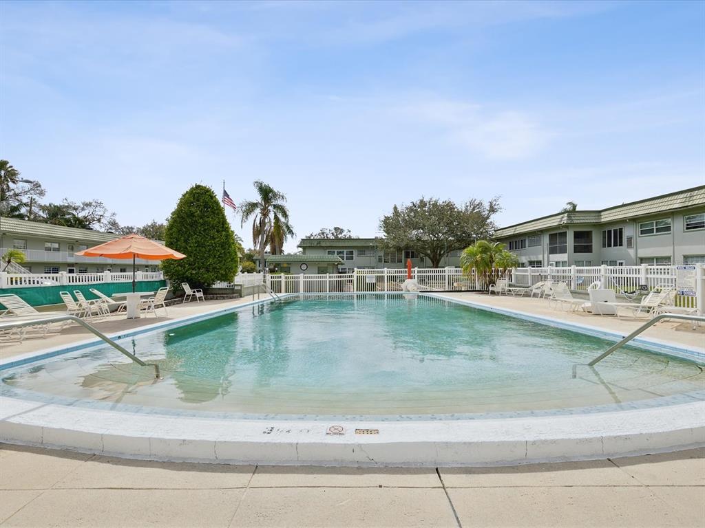 1433 South Belcher Road, Unit F20 Clearwater, FL 33764 - Photo 55 of 57 a view of swimming pool with outdoor seating and lake view
