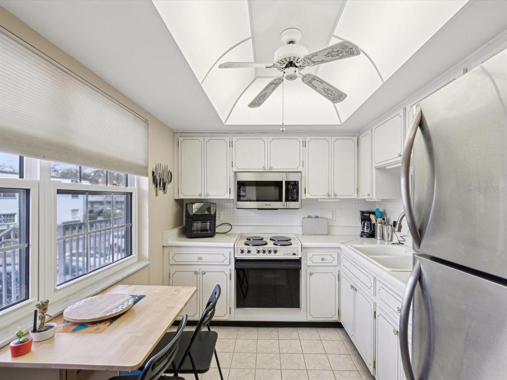 1433 South Belcher Road, Unit F20 Clearwater, FL 33764 - Photo 8 of 57 a kitchen with a stove a sink and a refrigerator