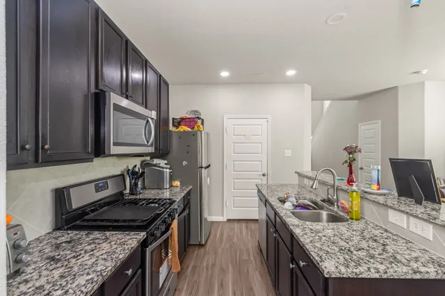a kitchen with granite countertop stainless steel appliances and wooden cabinets