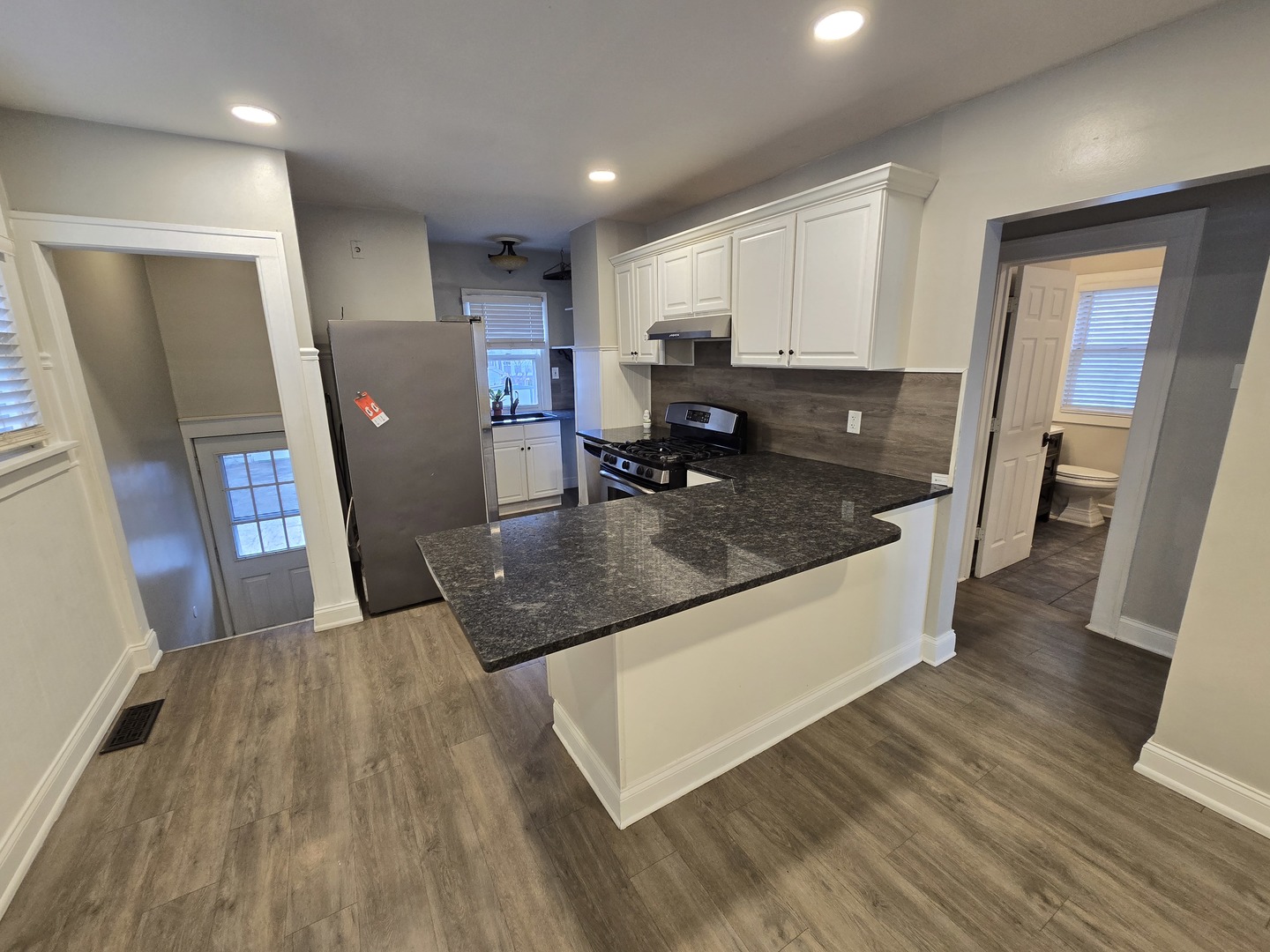 185 Pick Avenue Elmhurst, IL 60126 - Photo 7 of 24 a large kitchen with stainless steel appliances granite countertop a refrigerator a stove and a sink with wooden floor