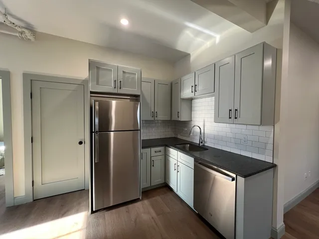 a kitchen with stainless steel appliances granite countertop a refrigerator a sink and a stove