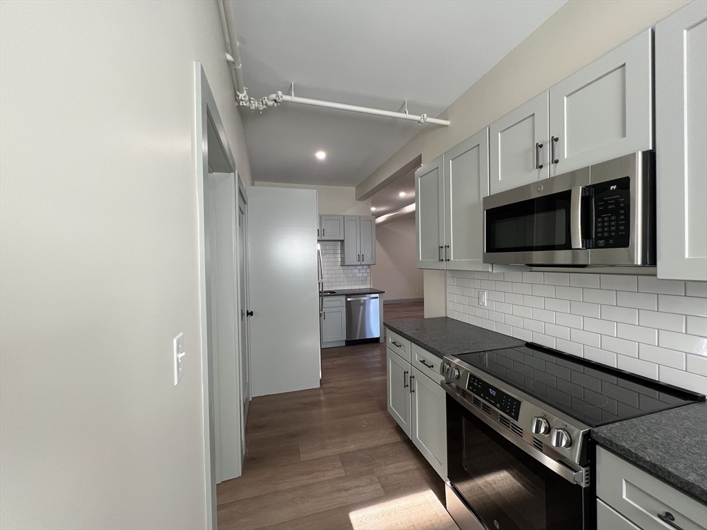 160 Seabury Street, Unit 9 Fall River, MA 02720 - Photo 2 of 14 a kitchen with stainless steel appliances and wooden floor