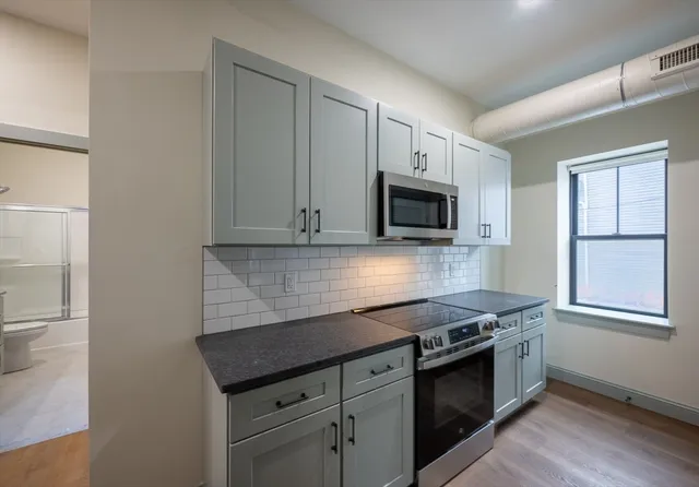 a kitchen with granite countertop a stove and a microwave