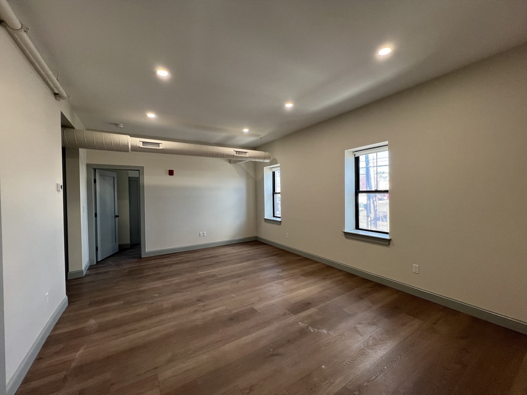 160 Seabury Street, Unit 9 Fall River, MA 02720 - Photo 7 of 14 an empty room with wooden floor and windows
