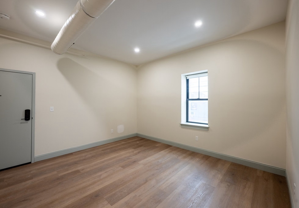 160 Seabury Street, Unit 9 Fall River, MA 02720 - Photo 8 of 14 an empty room with wooden floor and windows