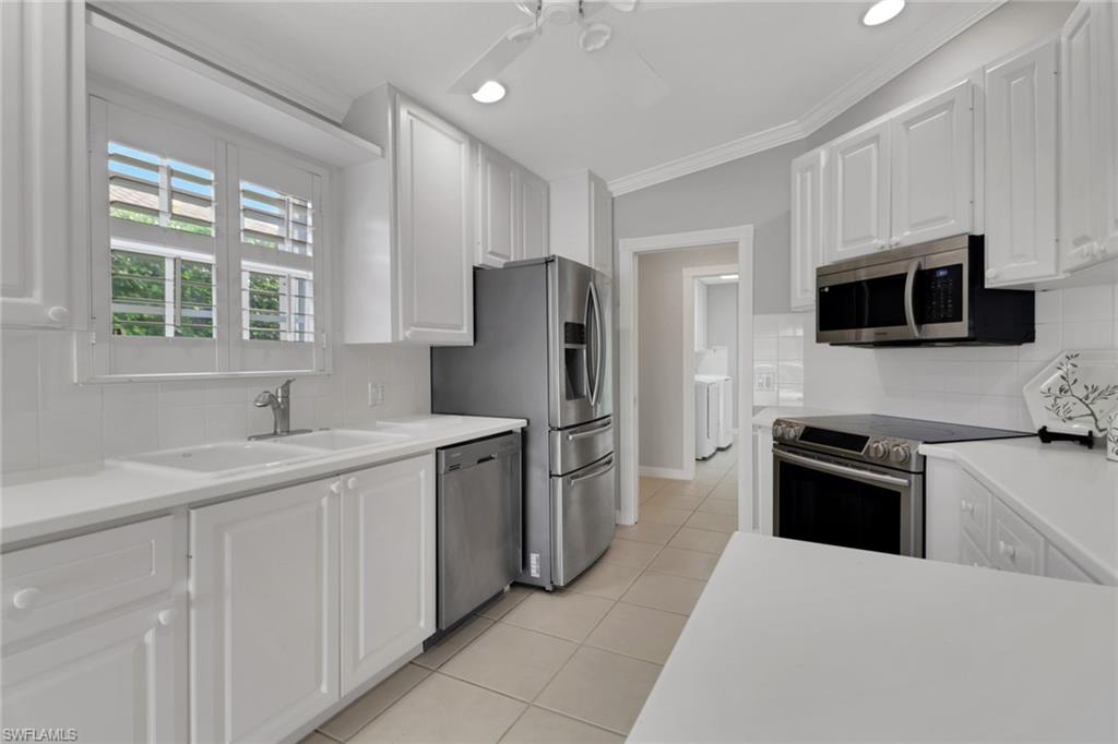 3751 Exuma Way Naples, FL 34119 - Photo 12 of 33 a kitchen with a sink stove and refrigerator