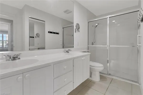 a bathroom with a double vanity sink toilet and shower