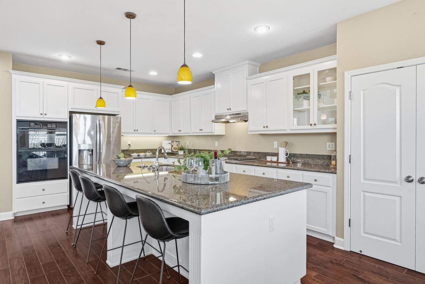 806 Mornington Court San Ramon, CA 94582 - Photo 17 of 58 a kitchen with stainless steel appliances granite countertop a stove a kitchen island a dining table and chairs with wooden floor