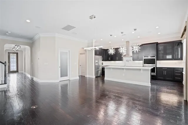 a large white kitchen with a large window a kitchen view and a refrigerator