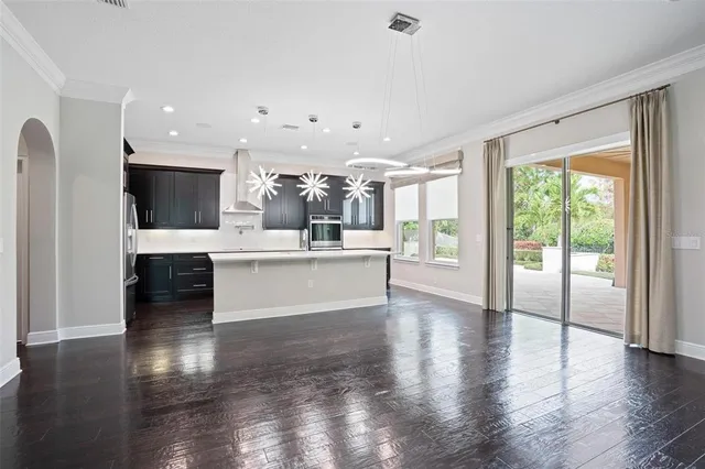 a large kitchen with stainless steel appliances a large counter top a stove and a refrigerator