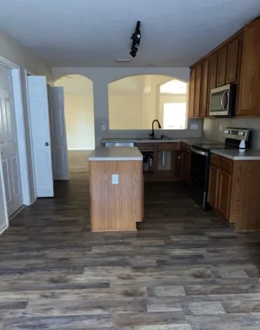 a kitchen with stainless steel appliances wooden floors and wooden cabinets