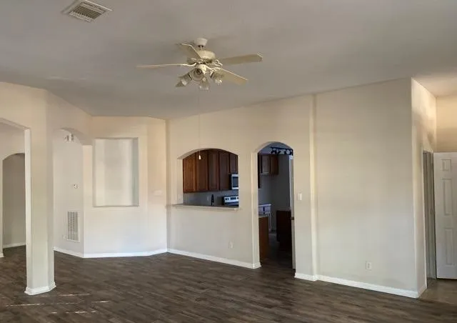 a view of a livingroom with wooden floor and a ceiling fan