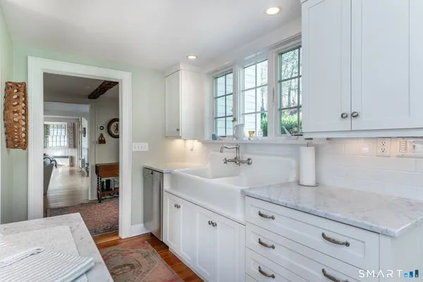 a kitchen with granite countertop white cabinets and stainless steel appliances