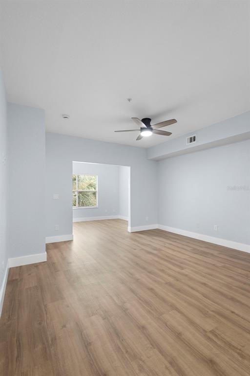 822 Camargo Way, Unit 307 Altamonte Springs, FL 32714 - Photo 25 of 46 a view of an empty room with wooden floor and a ceiling fan
