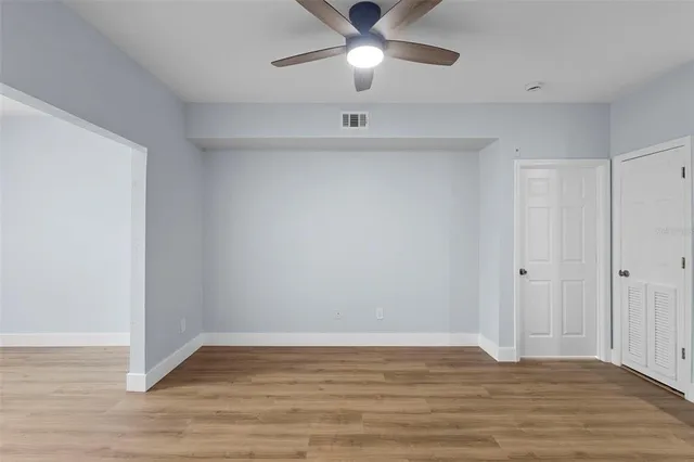a view of an empty room with wooden floor