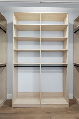 a view of walk in closet with empty racks