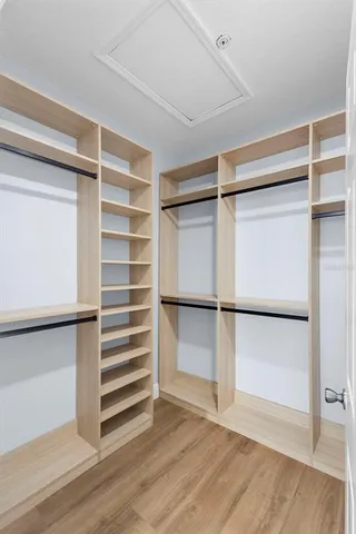 a view of an empty room with wooden floor and cabinet