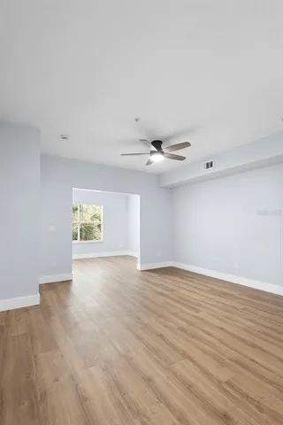 an empty room with wooden floor and windows