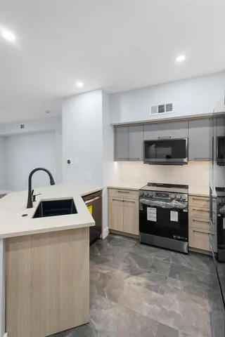 a kitchen with stainless steel appliances a stove sink and cabinets