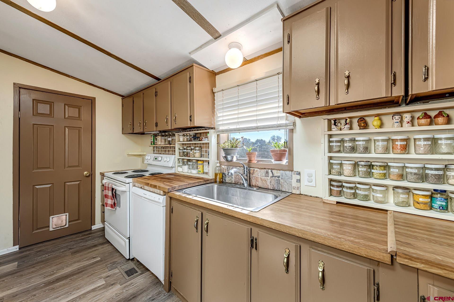 20984 Upland Road Cedaredge, CO 81413 - Photo 22 of 34 a kitchen with stainless steel appliances granite countertop a sink and a stove