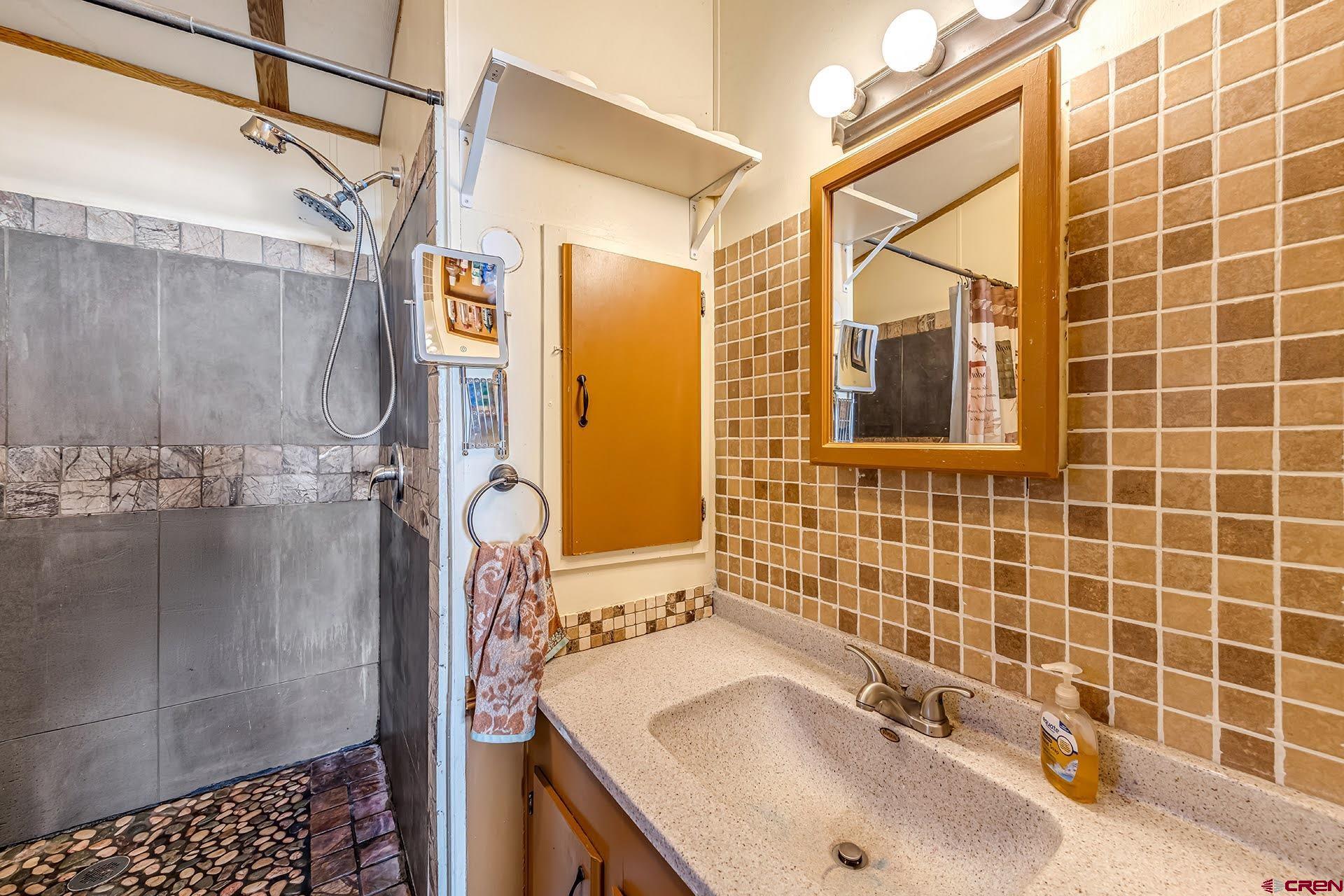20984 Upland Road Cedaredge, CO 81413 - Photo 31 of 34 a bathroom with a sink shower and a mirror
