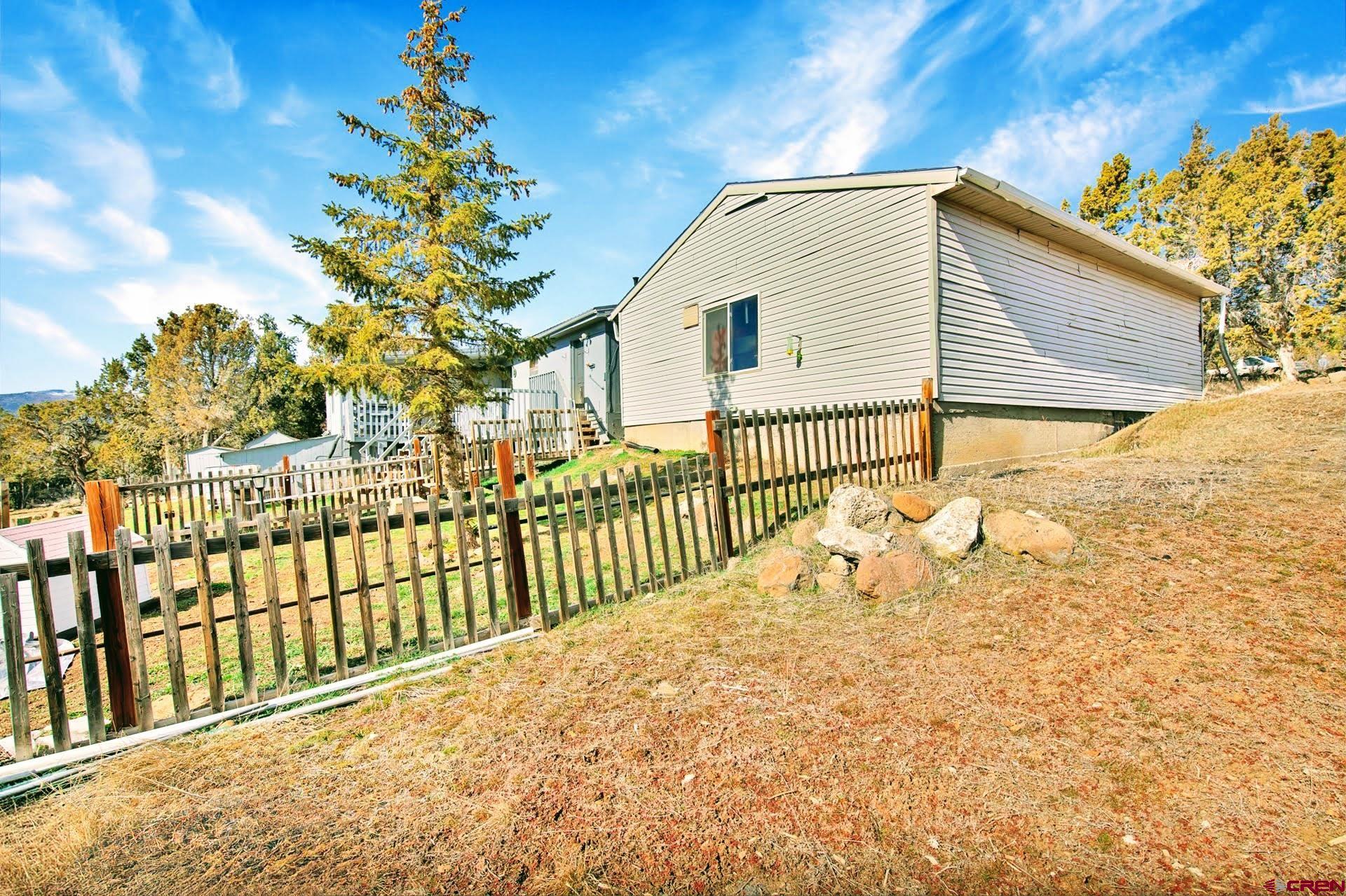 20984 Upland Road Cedaredge, CO 81413 - Photo 10 of 34 a view of a house with a wooden fence