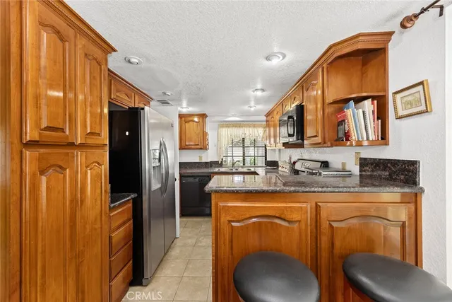 a kitchen with stainless steel appliances granite countertop a sink a stove and refrigerator