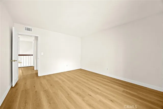 a view of empty room with wooden floor and cabinet