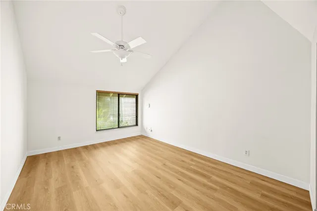 an empty room with a window and a ceiling fan