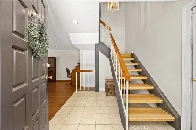 a view of staircase with lots of frames on wall and a large window