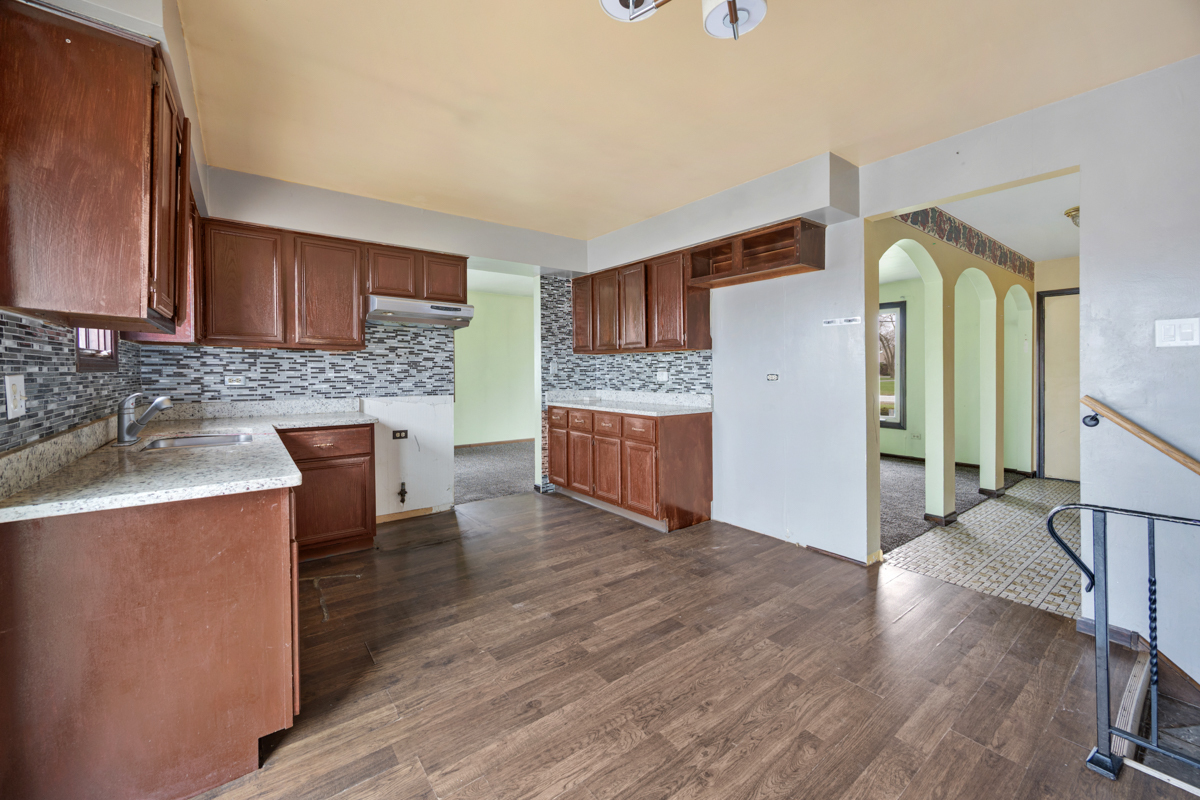 5916 West 127th Street Alsip, IL 60803 - Photo 10 of 22 a kitchen with granite countertop a stove and a wooden floors