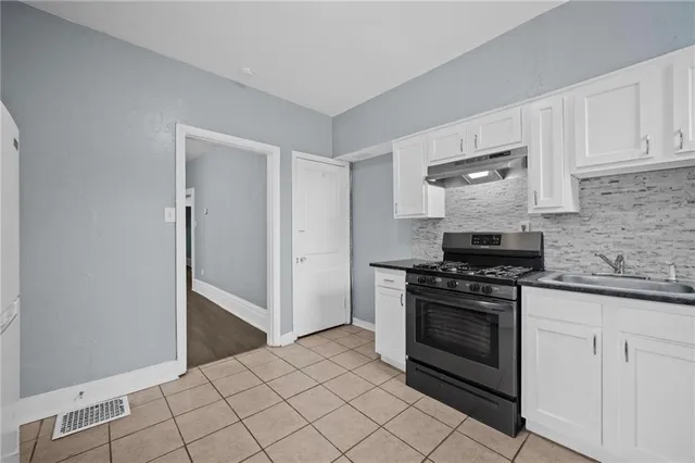a kitchen with a stove top oven and cabinets