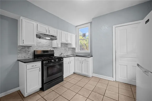 a kitchen with stainless steel appliances granite countertop a stove a sink and a refrigerator