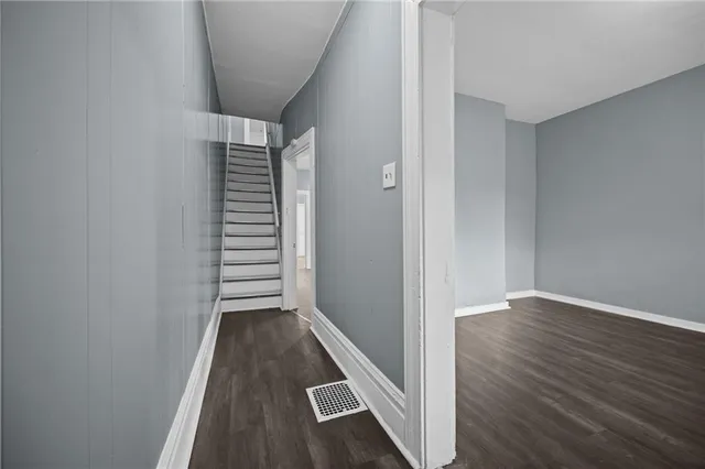 a view of a hallway with wooden floor and staircase