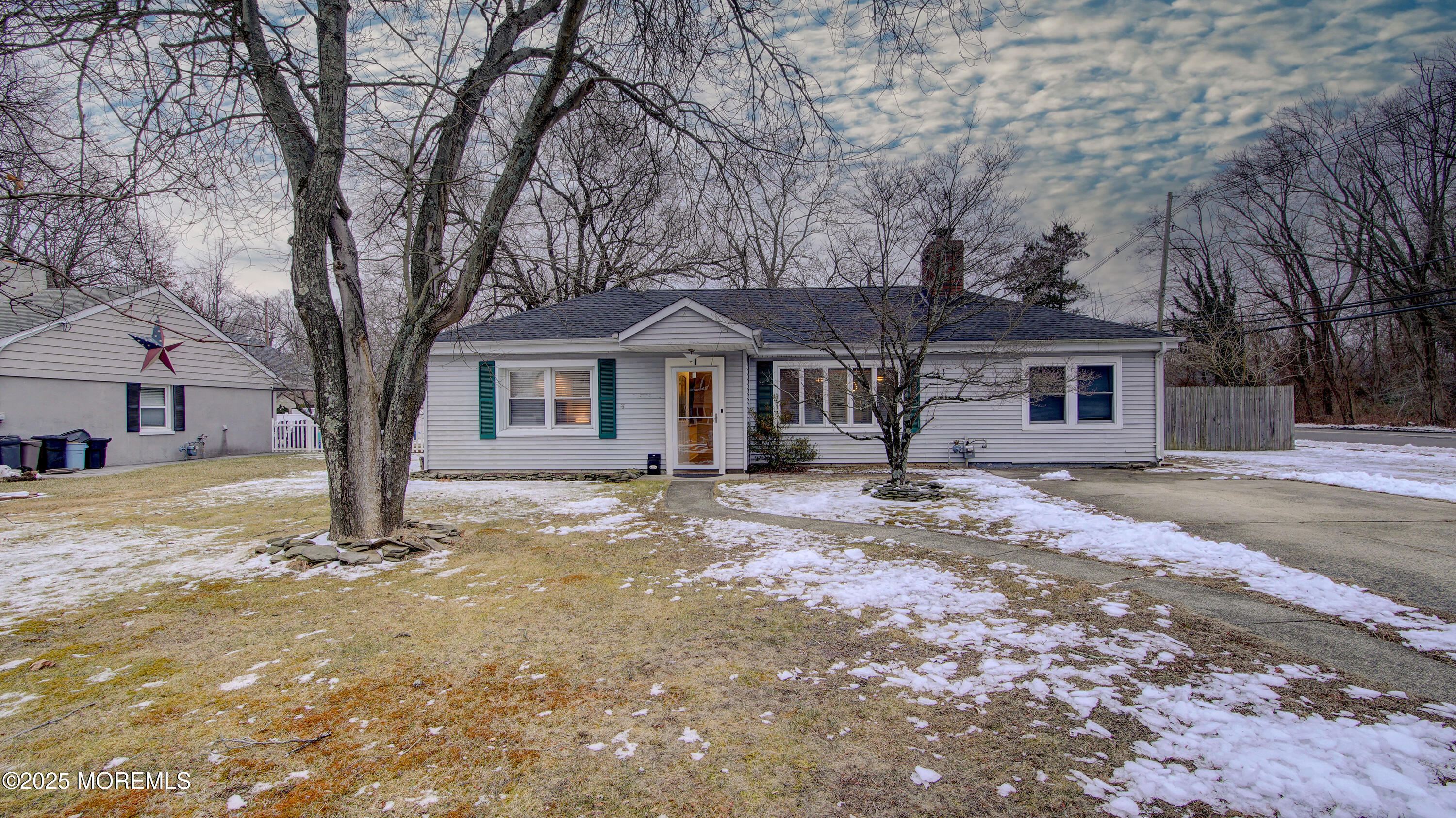 a front view of a house with a large tree