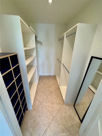 a view of walk in closet with empty racks