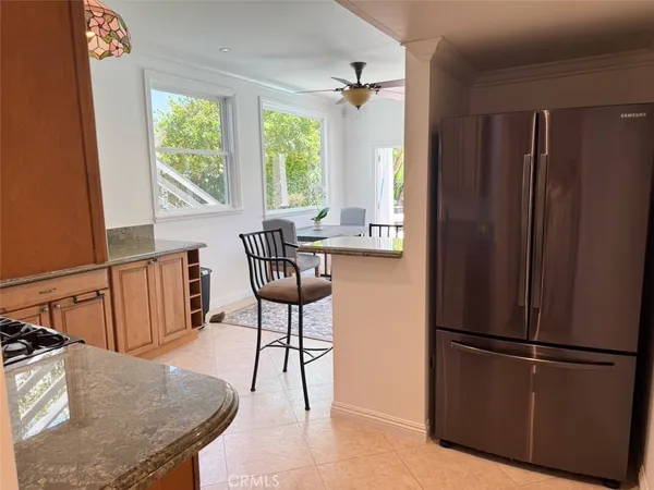 a kitchen with stainless steel appliances granite countertop a refrigerator a stove and a sink with large window