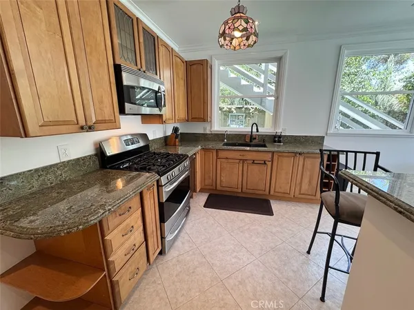 a kitchen with stainless steel appliances granite countertop a stove a sink and a microwave