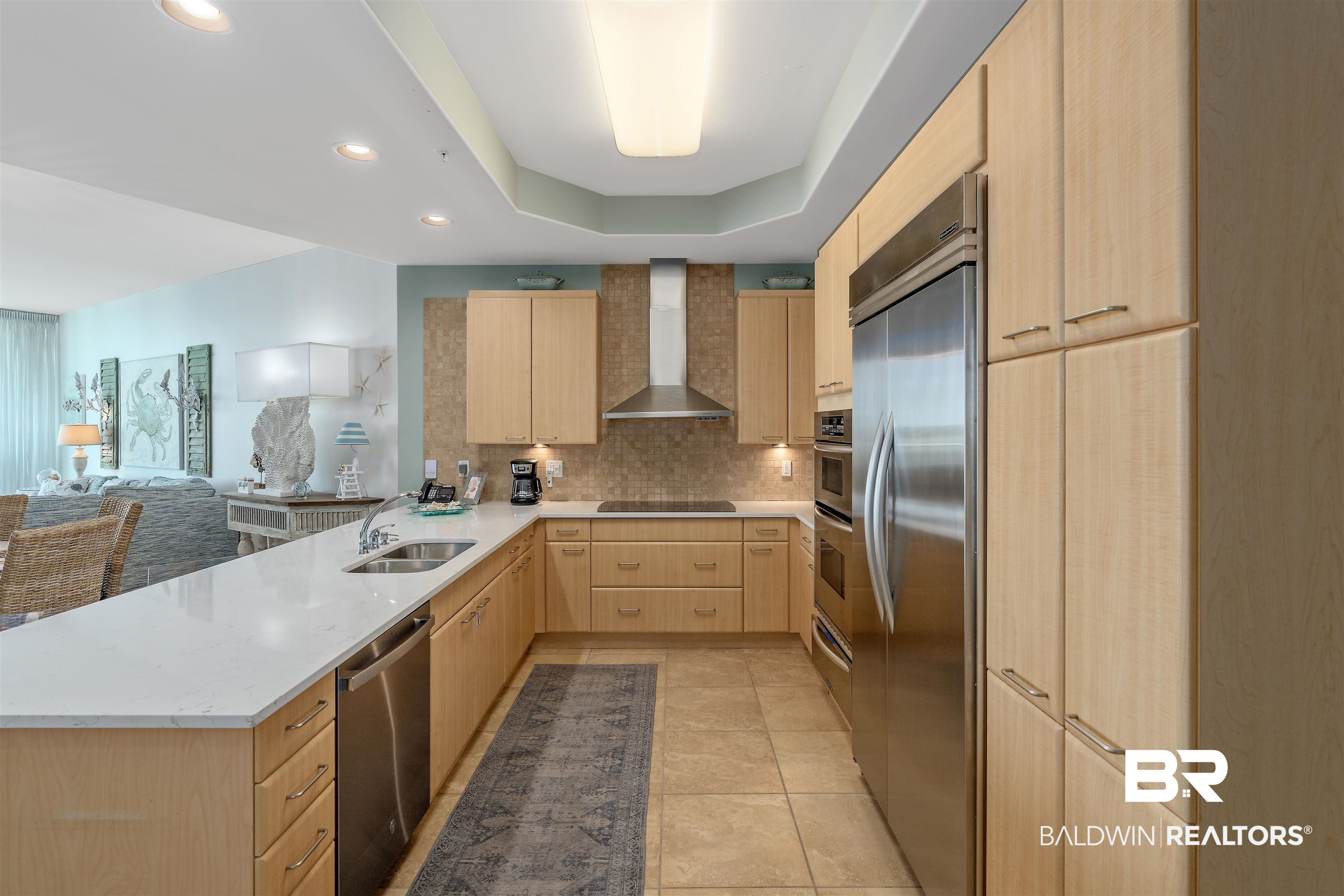 28107 Perdido Beach Boulevard, Unit DPH06 Orange Beach, AL 36561 - Photo 5 of 70 Kitchen featuring sink, appliances with stainless steel finishes, wall chimney exhaust hood, light brown cabinetry, and a tray ceiling