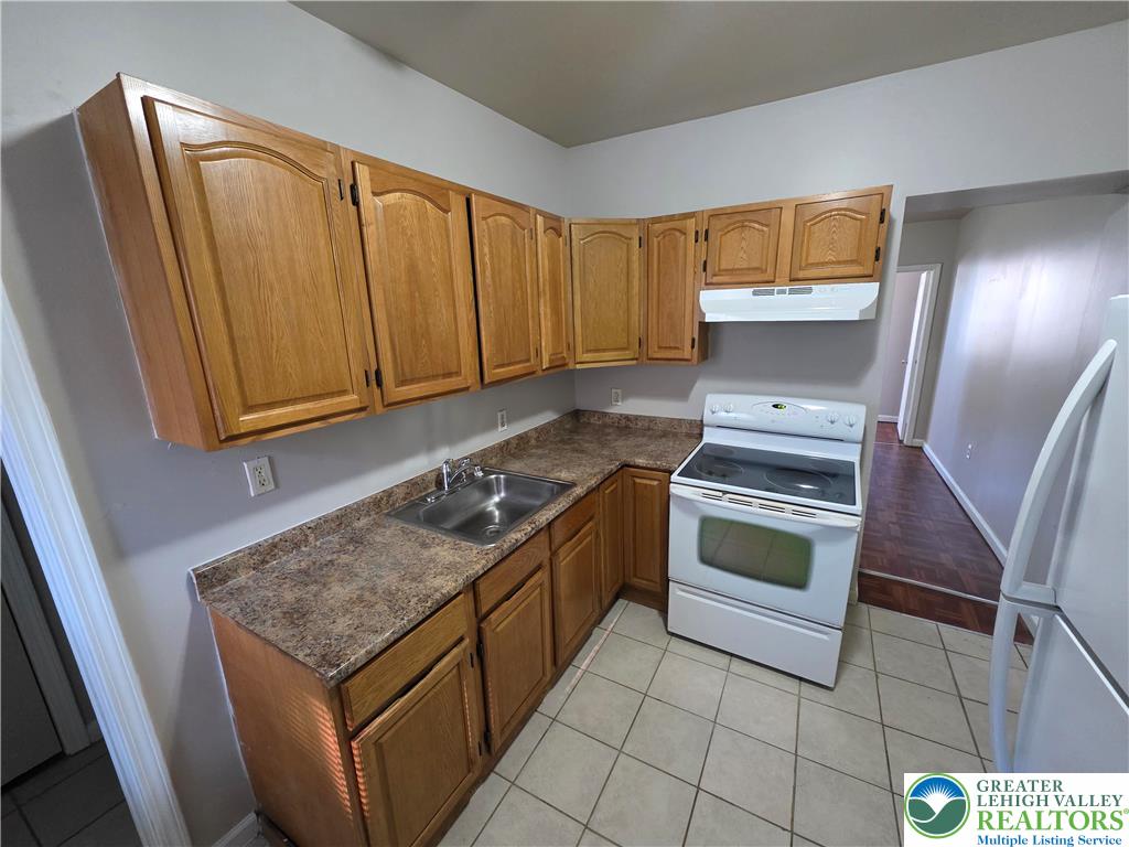609 Walnut Street, Unit A Easton, PA 18042 - Photo 3 of 8 a kitchen with granite countertop a sink stove and cabinets