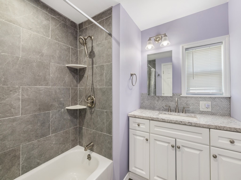953 Laurel Circle Sebastian, FL 32976 - Photo 28 of 33 a bathroom with a granite countertop sink a mirror and a bathtub